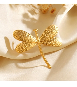 Detailed close-up of a golden dragonfly ring with hammer texture on white silk fabric