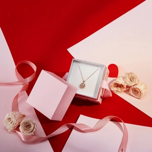 Collier fleur dorée élégant dans son écrin rose avec rubans et roses séchées décoratives