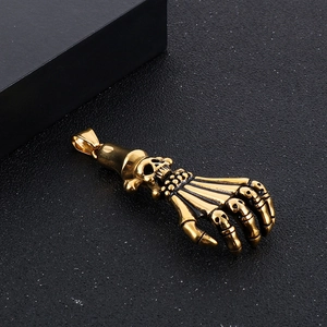 Detailed close-up of a golden ghost claw pendant showing fine bone textures on black surface