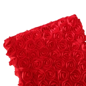 Détail de l'applique de rose en satin 3D sur une robe bustier moulante rouge vif