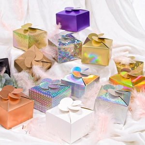 Colorful laser paper gift boxes with flower top closure on soft white fabric
