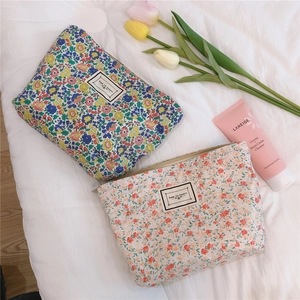 Detail of floral makeup bags with zipper closure and embroidered Time to Party label