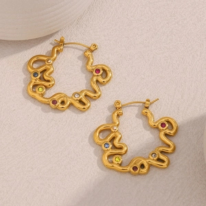 Detail of twisted 18K gold plated earrings with colorful rhinestones on ivory background