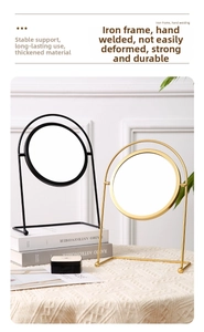Detail of round desktop makeup mirrors in matte black and gold with arched iron frames