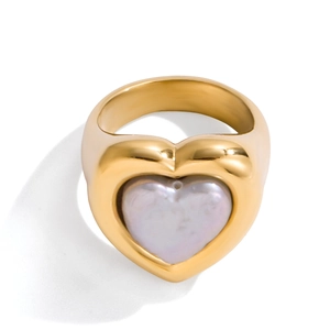 Elegante anillo de corazón dorado con incrustación de nácar púrpura sobre fondo blanco