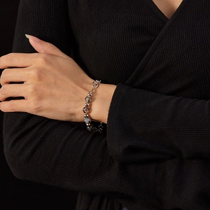 Detail view of natural stone bead bracelet with stainless steel clasp on model wrist