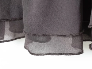 Detailweergave van de donkere mesh stiksels en fijne geplooide rand op deze bodycon jurk