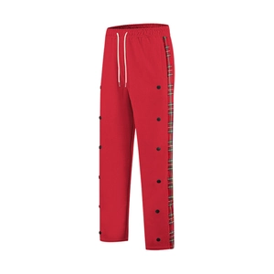Detail of red joggers with white drawstrings, plaid side stripes and side snap buttons