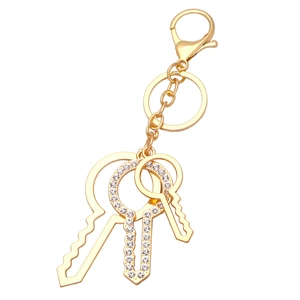 Elegant gold keychain with three keys including one encrusted with sparkling rhinestones