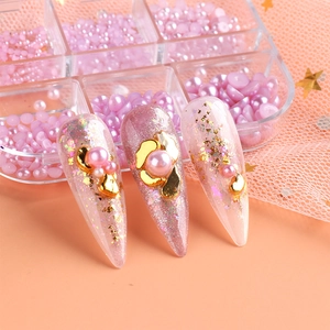 Pink nail art tips with gold flakes and assorted pink pearls in a clear storage box