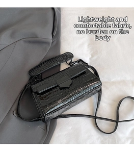 Detail of black crocodile texture rectangle handbag with geometric metal clasp buckle