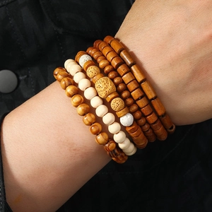 Detail of layered handmade wooden bead bracelets with coconut shell and stone on a wrist