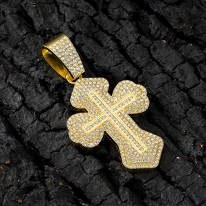 Iced out gold hip hop cross pendant with clear rhinestones on black textured wood background