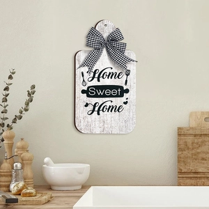 Close-up of Home Sweet Home wooden cutting board wall decor with black and white bow