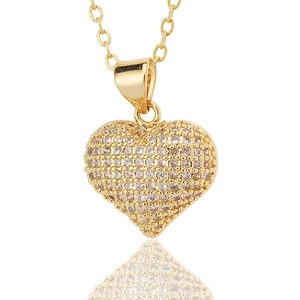 Macro detail of gold-plated heart pendant necklace with shimmering micro-pave cubic zirconia