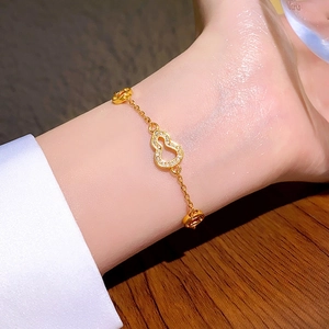 Bracelet doré avec pendentif gourde évidée orné de zircons blancs étincelants