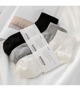Piatto di calzini in cotone nero, grigio e bianco con oggetti di scena minimalisti