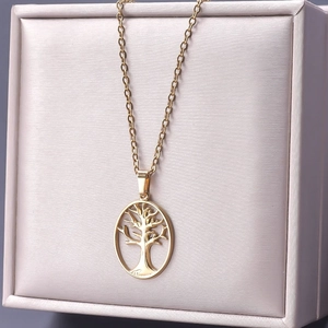 Detailed view of a gold 18k plated stainless steel tree of life necklace on silk