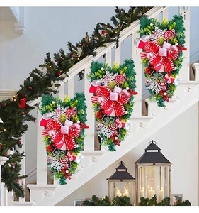 Christmas teardrop wreath with red bows and candy canes displayed on stairs