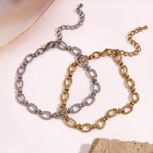 Detail of interlocking oval link anklets in silver and 14K gold plated stainless steel
