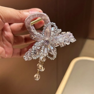 Detail of light purple floral hair claw with sparkling crystal beads and tassels