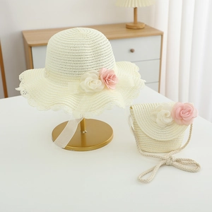Detail of girls straw sun hat and matching bag with floral lace decorations