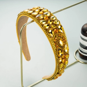 Dettaglio di un cerchietto largo dorato con strass e cristalli scintillanti