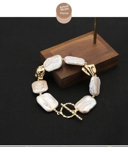 Close-up of Baroque pearl bracelet with 18k gold-plated OT clasp on wooden stand