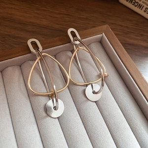 Détail macro de boucles d'oreilles géométriques avec finition or et argent