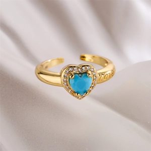 Macro shot of gold-plated heart ring with blue zircon and LOVE engraving detail
