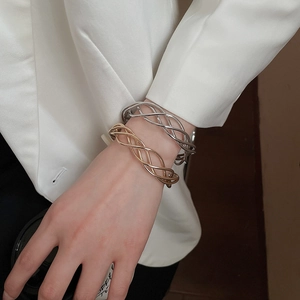 Close-up of gold and silver irregular twisted metal bangles worn on the wrist