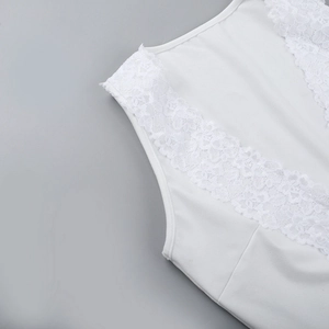 Dettaglio del bordo in pizzo bianco e del tessuto liscio sul top corto sexy con scollo a V