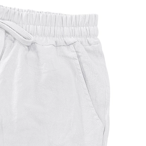 Detail view of elastic waist with drawstring and side pockets on white linen pants