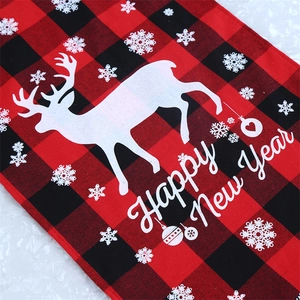 Close-up of red and black buffalo plaid table runner with reindeer and Happy New Year print
