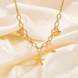 Detailed close-up of golden nautical charms including dolphin and starfish on silk fabric