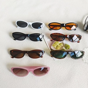 Vintage cat eye sunglasses in multiple colors displayed on white fabric with props