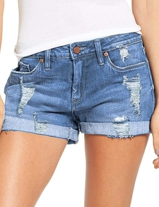 Detalle de los pantalones cortos de mezclilla con agujeros desgastados y bajo doblado