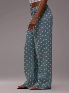Side view of light blue wide-leg denim pants featuring white polka dot patterns