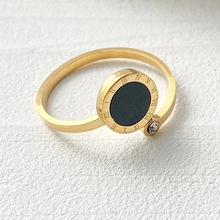 Close-up of golden stainless steel ring featuring roman numerals and a tiny crystal