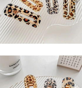 Detail of leopard print acrylic hair clips in rectangular and drop shapes on glass tray