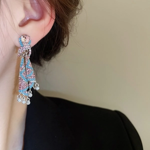 Detail of luxury colorful tassel drop earrings with pink crystals and blue beads on model