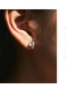 Detail of a 1ct moissanite stud earring with classic 3-prong silver setting on ear