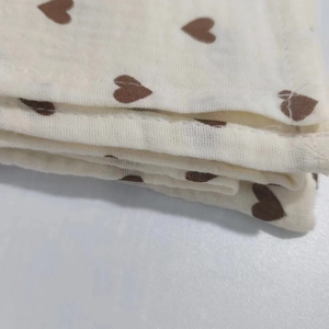 Macro view of double-layer cotton muslin fabric with soft brown heart pattern texture