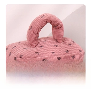 Detail of pink corduroy makeup bag featuring heart patterns and a comfortable padded handle