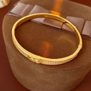 Elegante vergulde armband met micro-geplaveid CD-logo en witte kristallen afwerking