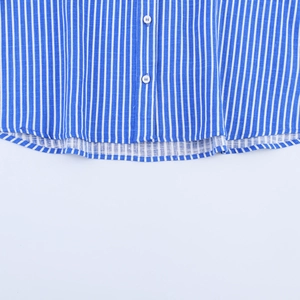 Detail of blue and white striped shirt featuring white buttons and a linen-textured hemline