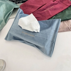 Detail of colorful velvet tissue pouches with gold 'Happiness' embroidery and soft texture