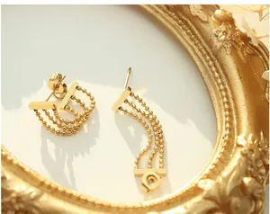 Détail de boucles d'oreilles à franges dorées sur fond de cadre vintage