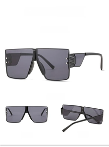 Detail view of square rimless sunglasses in black with metal rivets and wide temples