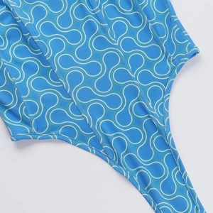 Close-up of blue swimwear fabric with white abstract pattern and neat stitching details